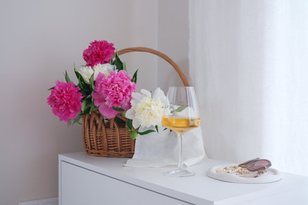 A beautiful bouquet of vibrant flowers in basket with exquisite wine and fresh grapes, perfect for a serene ambiance.の写真素材