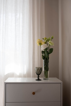 tranquil early light casting subtle shadows over vintage ceramics glass and soft floral arrangements...