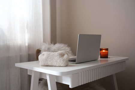 Homeoffice - Notebook, cosmetic bag, candle on white desk.の写真素材
