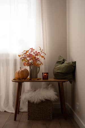 cozy autumn scene, autumn harvest in cozy setting, warm autumn interior with pumpkins, pillow, autumn leaves and candles on wooden bench.の写真素材