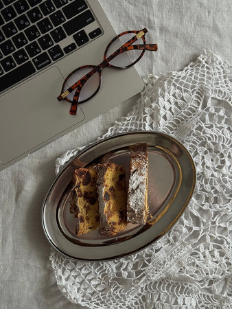 Laptop Glasses Plate With Biscotti Slices, Crochet Doily Under Silver Platter, Chocolate Chips Visible, Warm Natural Light On Wooden Tabletop, Quiet Afternoon Break, Relaxedの写真素材