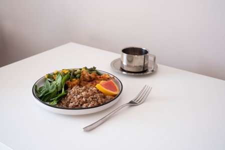 Minimalist healthy meal: plate with buckwheat, grilled chicken, fresh spinach, green beans, corn,...