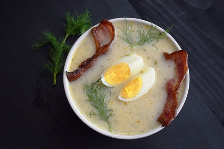 soup with dill, egg and bacon on a black background.の写真素材