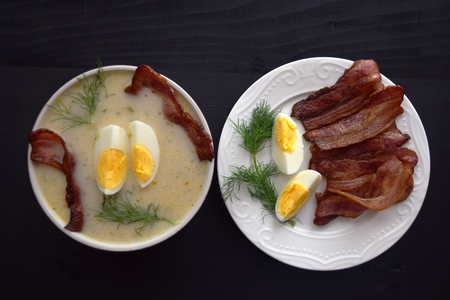 soup with dill, egg and bacon on a black background.の写真素材