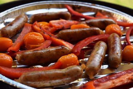 Grilling sausages and vegetables and spices on the grillの写真素材