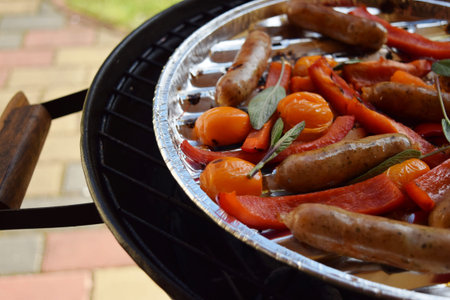 Grilling sausages and vegetables and spices on the grill