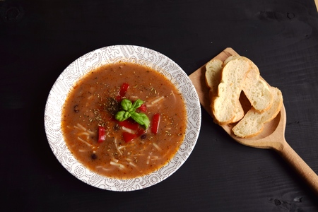 Homemade soup with beans and vegetables on a black wooden background.の写真素材
