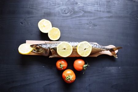 Smoked fish with lemon, on wooden board, Mackerelの写真素材