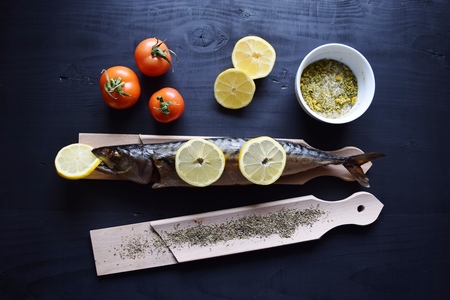 Smoked fish with lemon, on wooden board, Mackerelの写真素材