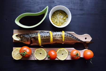 Smoked fish with lemon, on wooden board, Mackerel