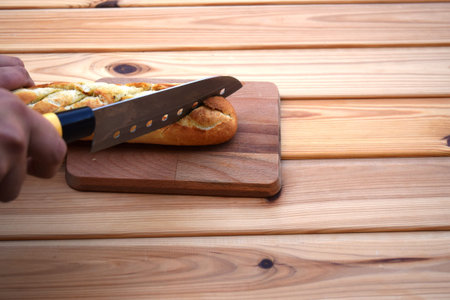 baguette, knife on cutting board bright wooden backgroundの写真素材