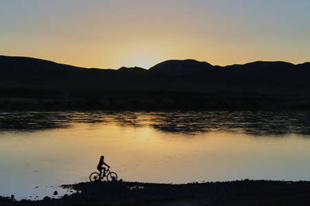 Mountainbiker girl near mountain lakeの写真素材