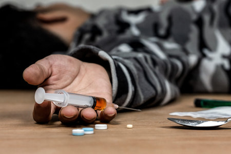 Addict man dead after inject drug overdose with syringe injection heroin to hand.Social disaster and...