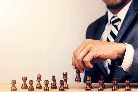 Businessman playing chess board game for development analysis new strategy planning.The battle of competition and strategy ideas with market mechanism.の写真素材