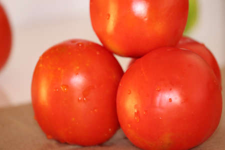close up of fresh red delicious tomatoes on an old wooden tabletop background with place for text. Color toning. - Imageの写真素材