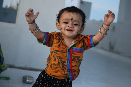 Indian baby boy of age 1 Year old in a playground.Cute happy baby face with black hair.Closeup of...