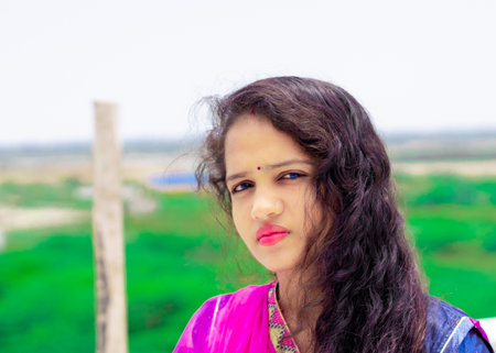 Head shot Portrait of happy Rajasthani young girl with red lipstick on gorgeous lips looking at...