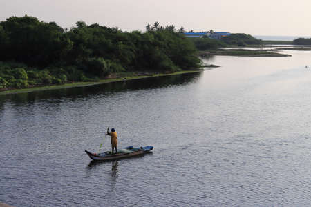 Chennai, Tamil nadu , India . Oct 07,2020.In the morning, a fisherman rode in a wooden boat to catch fish from the lake of water.のeditorial素材