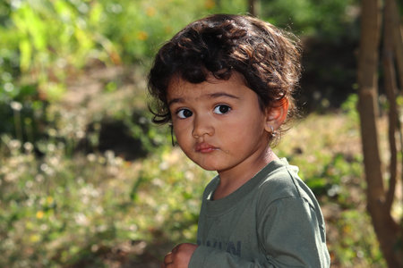 closeup A small Indian child looking obliquely in the garden, india. concept for Today's children tomorrow's future, childhood memories, smile on face, daily routine,Facial Reaction, face expressionの写真素材