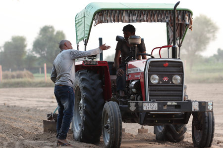 Pali Rajasthan, India- OCt 29, 2022.Close-up editorial photo of A farmer sitting on a tractor talks...