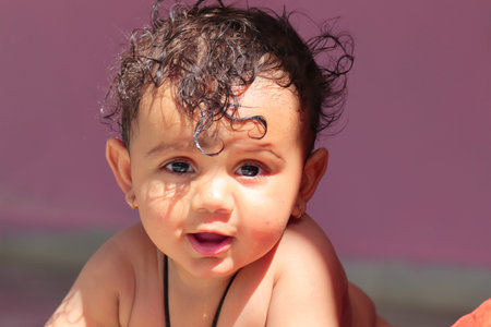 Close-up of Photo of A little cute indian newborn baby smiling at the camera with natural sunlight...