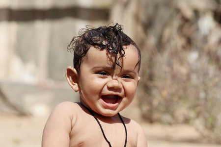 Close-up photo Portrait of Indian Cute baby boy playing outside nature and laughing at the camera, Rajasthan Indiaの写真素材