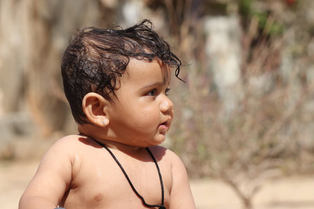 Close-up photo side view of beautiful happy baby boy with smiling faces, Rajasthan Indiaの写真素材