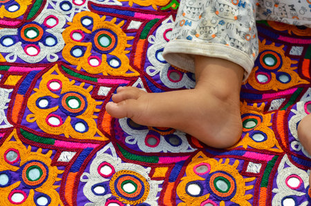 Indian patchwork carpet in Rajasthan, baby leg on Indian embroidery ,Fabric with floral type design...