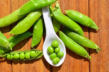 peas beans on wooden table,beautiful green peas beans on wooden,close up view healthy peas,white spoon in peasの写真素材