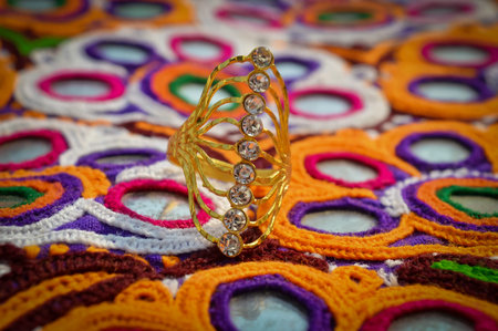 golden diamonds ring on embroidery background close up view,small diamond stone on Golden ring,の写真素材