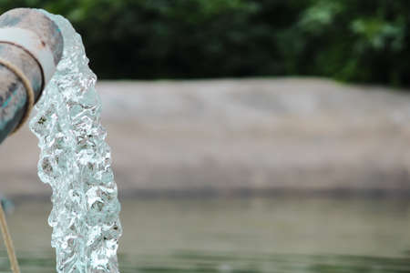 Pumping water out of plastic pipe into the ground,Water from a well filled a pond for irrigation,Irrigation water from the source,Water flow from large pump tube in Farm,being flush out a heavy tube,の写真素材