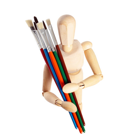 Painter's wooden model holding paintbrushes isolated on whiteの写真素材