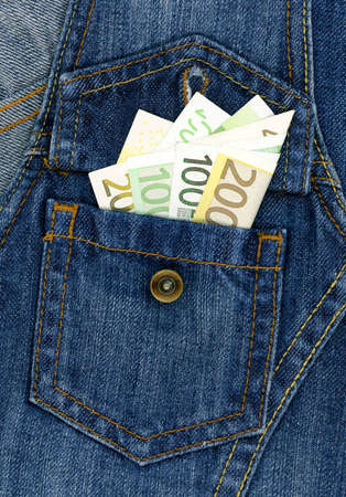 Easy money concept - closeup of many banknotes in blue jeans pocketの写真素材