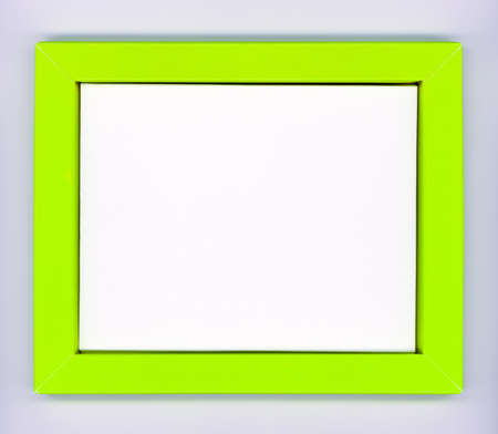 Empty green paper frame with white background on gray wallの写真素材