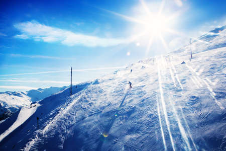 Unrecognizable skiers having fun in mountains skiing at sunsetの写真素材