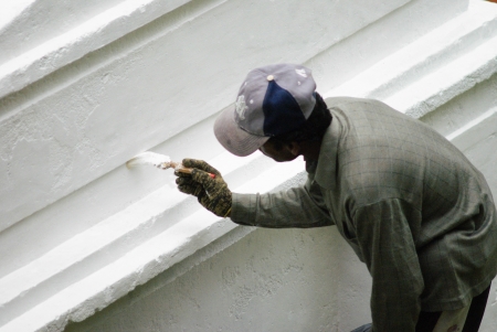 A male painter is painting white wallの写真素材