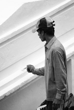 A male painter is painting white wallのeditorial素材