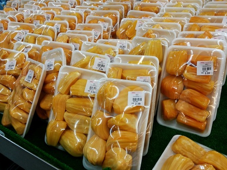 Packed jackfruits stacked for retail at the marketの素材