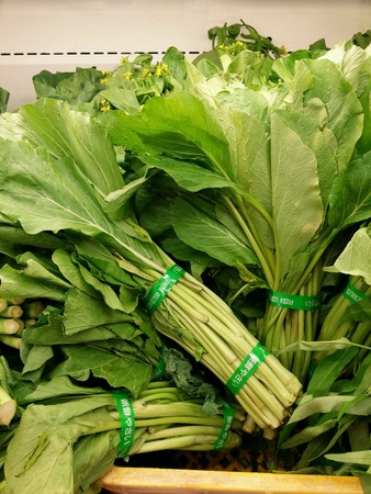 Fresh mustard greens or sawi piled for retail at the marketの素材