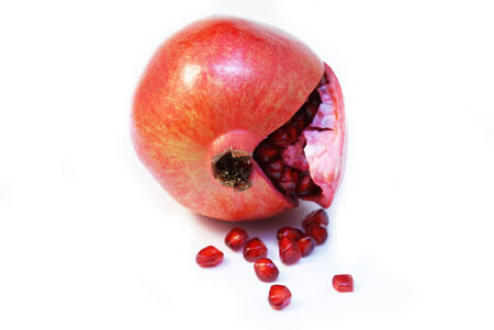 Fresh cut opened Pomegranate fruit or Buah Delima with seeds fallenの写真素材