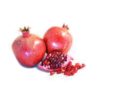 Two whole and a cut open ripe Pomegranate fruit or Buah Delimaの写真素材