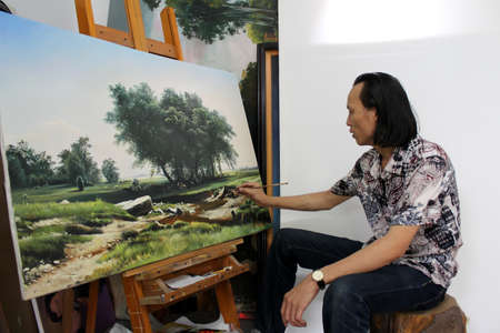 HAI DUONG, VIETNAM, July, 25: the artist is drawing a landscape painting in his studio on July, 25, 2013 in Hai Duong, Vietnamのeditorial素材