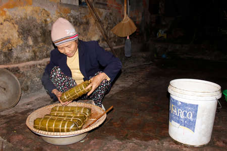 HAI DUONG, VIETNAM, November, 26: Asian woman packing rice cake on November 26, 2013 in Hai Duong, Vietnamのeditorial素材