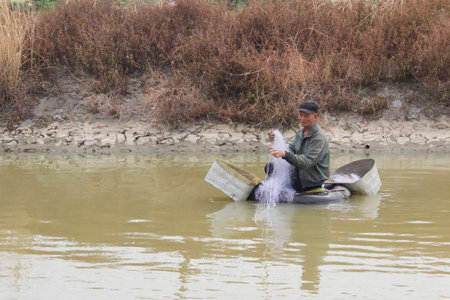 HAI DUONG, VIETNAM, JULY, 30: fisherman use boat and net fishing on a small river  on july, 30, 2014 in Hai Duong, Vietnam.のeditorial素材