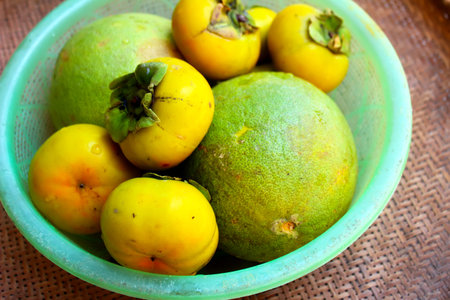 The persimmons and grapefruit in the basket