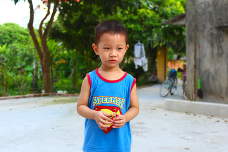 HAI DUONG, VIETNAM, September, 6: Boy play Tohe, the traditional toys in Vietnam made by colored rice powder on September, 6, 2014 in Hai Duong, Vietnam. This is the traditional toys in Vietnam is called: toheのeditorial素材