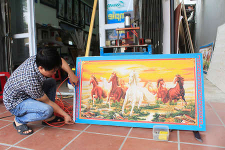 Haiduong, Vietnam, February, 17: Craftsman working on frame in frame shop on February, 17, 2015 in Hai Duong, Vietnamのeditorial素材