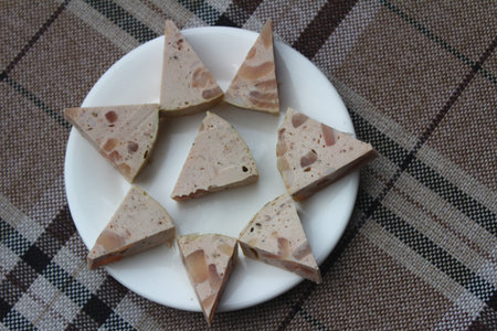 Slices of ham on a white plate, close-up