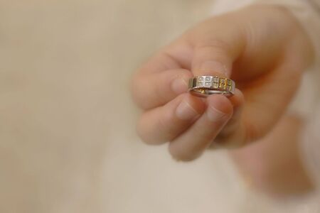 Womens Hand Holding a Wedding Ringの写真素材