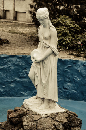 Statue of half-naked girl with a pitcher in the gardenの写真素材